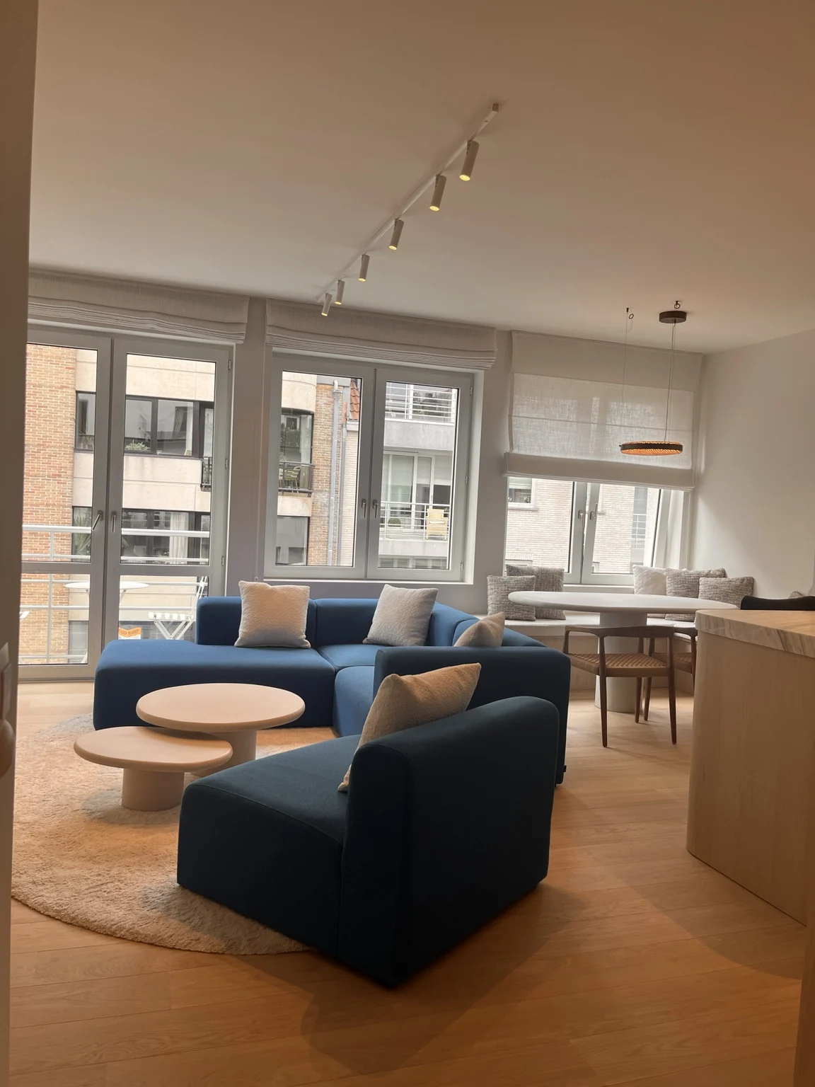 Lichte leefruimte van vakantieappartement Happ Knokke met blauwe zithoek en eethoek