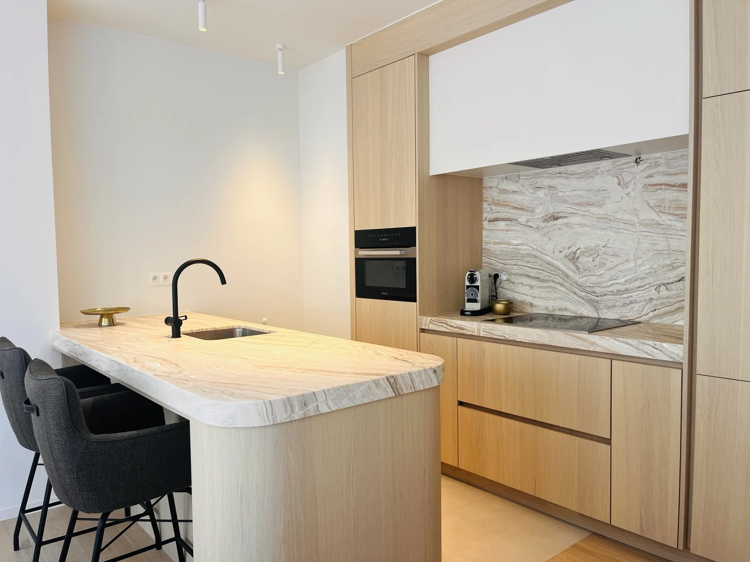 Open keuken van Happ Knokke met kookeiland en natuurstenen werkblad
