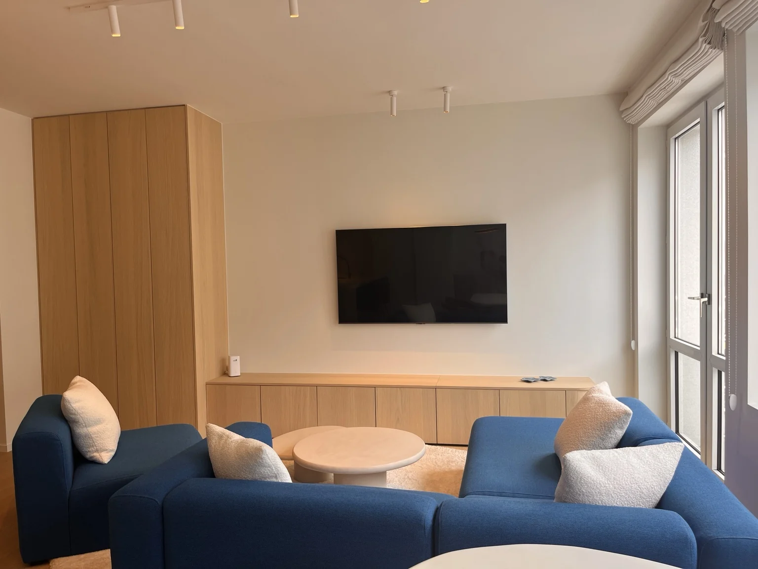 Leefruimte van Happ Knokke met 65-inch hd-tv en blauwe zithoek